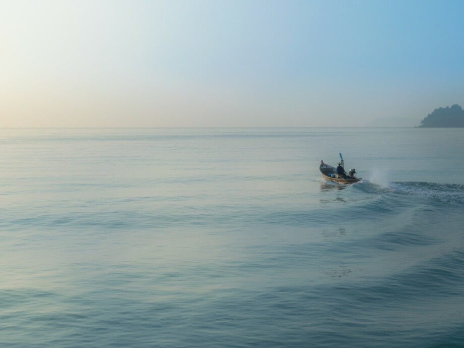 Small wooden fishing boat heading out to sea