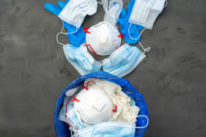 Used Infectious Masks And Medical Glove In The Trash Bin